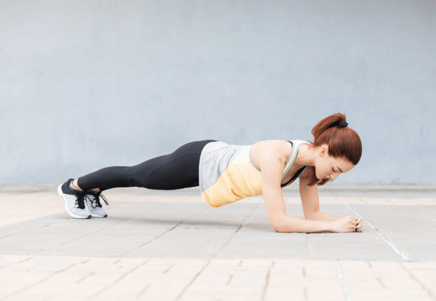 A woman holding a forearm plank with proper form
